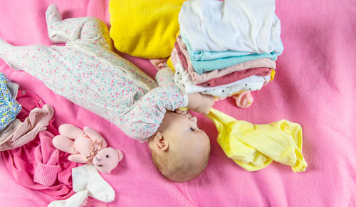 High angle view of cute baby girl lying on bed