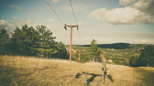 Wind turbines on field against sky