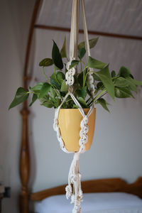 Close view of homemade white macrame plant hanger in bedroom