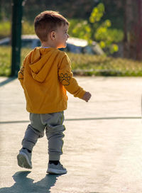 Rear view of boy looking at camera