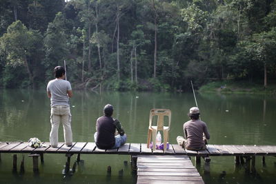 Rear view of men fishing in lake