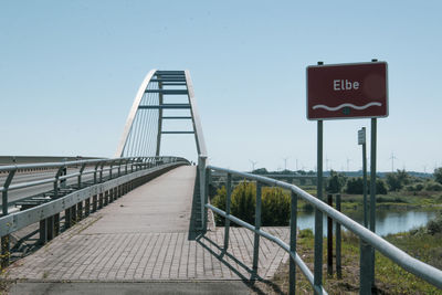 Information sign on bridge against sky