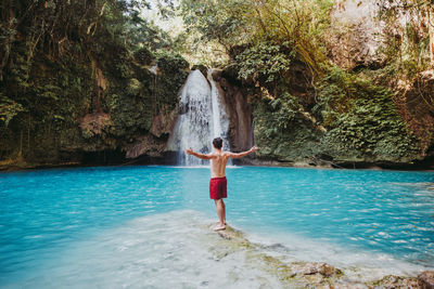 Man looking waterfall in forest