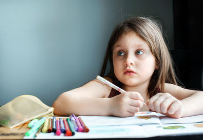 Close-up of cute girl drawing on book at home