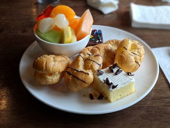 High angle view of fruits and pastries in plate on table