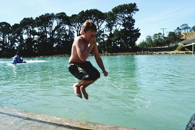 Boy jumping into swimming pool