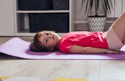 Tired girl lies on mat after workout at home.