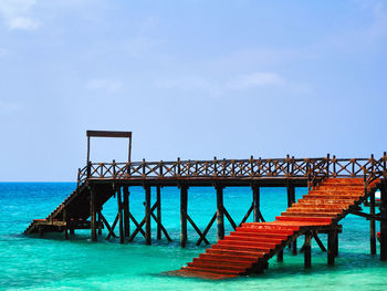 Pier over sea against blue sky