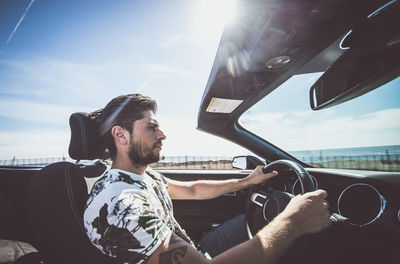 View of man driving car against sky