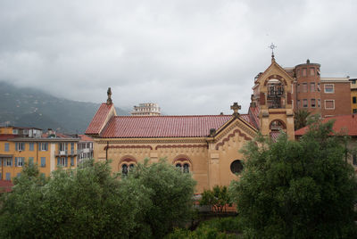 Buildings against cloudy sky