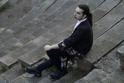 High angle view of thoughtful young man sitting on steps 