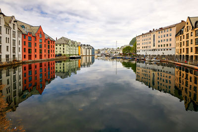 Reflection of buildings in river against sky