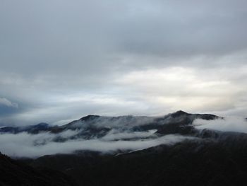 Scenic view of mountains against cloudy sky