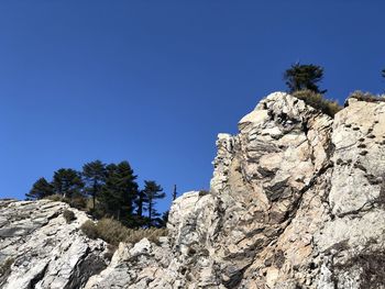 Low angle view of rocks against blue sky