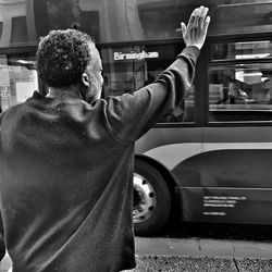 Rear view of man standing in car