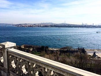 Bridge over city by sea against sky