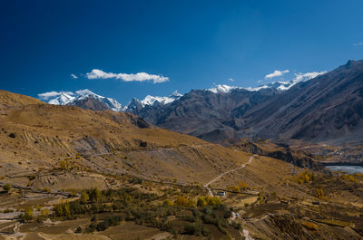 Scenic view of snowcapped mountains against blue sky