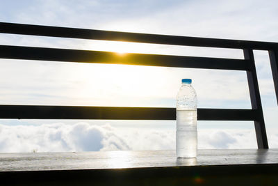 Water bottle on retailing wall against sky during sunset