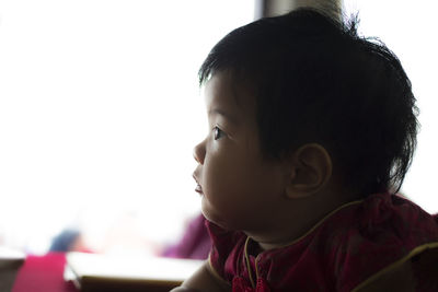 Close-up portrait of cute boy looking away at home