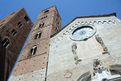 Low angle view of clock on building against clear sky