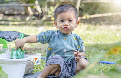 Little child shovels soil into pots to prepare plants for planting. toddler boy digging soil 