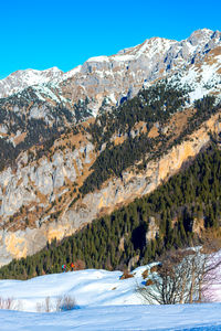 Scenic view of snowcapped mountains against clear sky