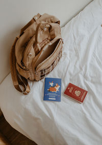 Beige backpack and passports on the white bed at home