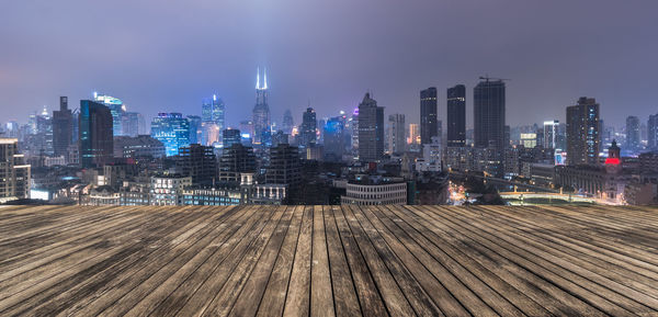 Illuminated buildings in city against sky at night