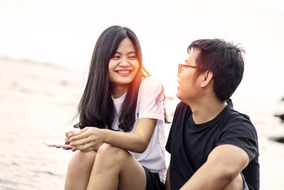 Happy couple sitting on beach