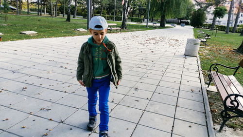 Full length of boy walking on footpath at park