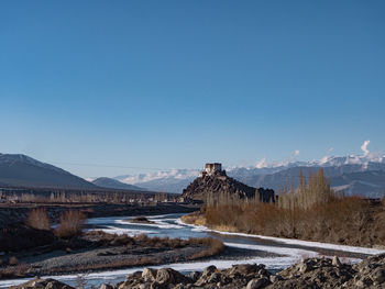 Scenic view of snowcapped mountains against clear blue sky