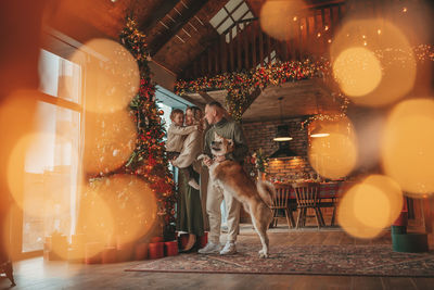 Candid authentic happy family during wintertime together enjoying holidays with dog at xmas