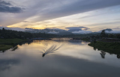 Scenic view of river against sky at sunset