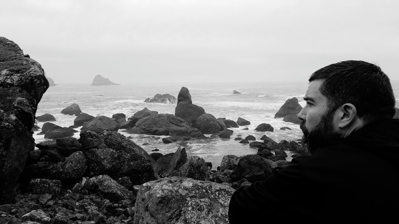 lifestyles, leisure activity, person, water, sea, headshot, young adult, waist up, standing, casual clothing, young women, rock - object, three quarter length, horizon over water, nature, copy space, sitting, sky