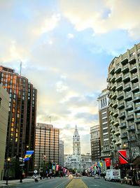 View of city street against cloudy sky