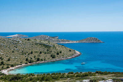 Scenic view of bay against clear blue sky