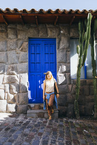 Full length rear view of woman standing against building