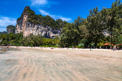 Scenic view of beach in island against blue sky