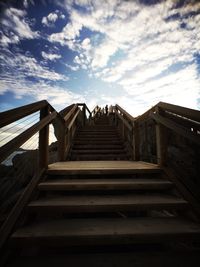 Low angle view of staircase against cloudy sky