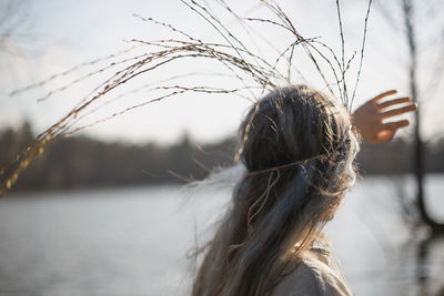 Close up looking at lake woman with long willow twigs crown portrait picture