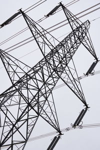 Low angle view of electricity pylon against clear sky