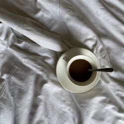 High angle view of coffee cup on bed