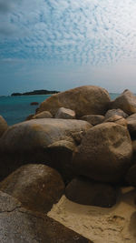 Rocks on beach against sky