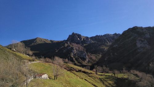 Scenic view of mountains against clear blue sky