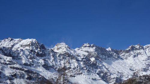 Snowcapped mountains against clear blue sky