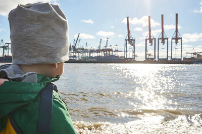 Rear view of boy in sea against sky