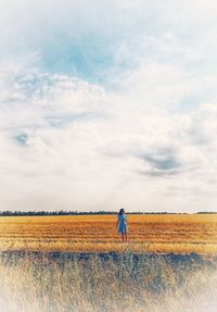 Rear view of man on field against sky