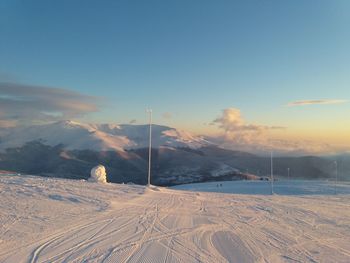 Snow covered landscape against sky