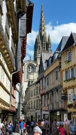 People on street in cathedral against sky in city