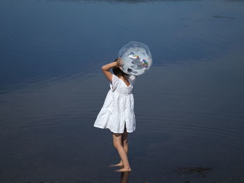 Rear view of woman standing against sea